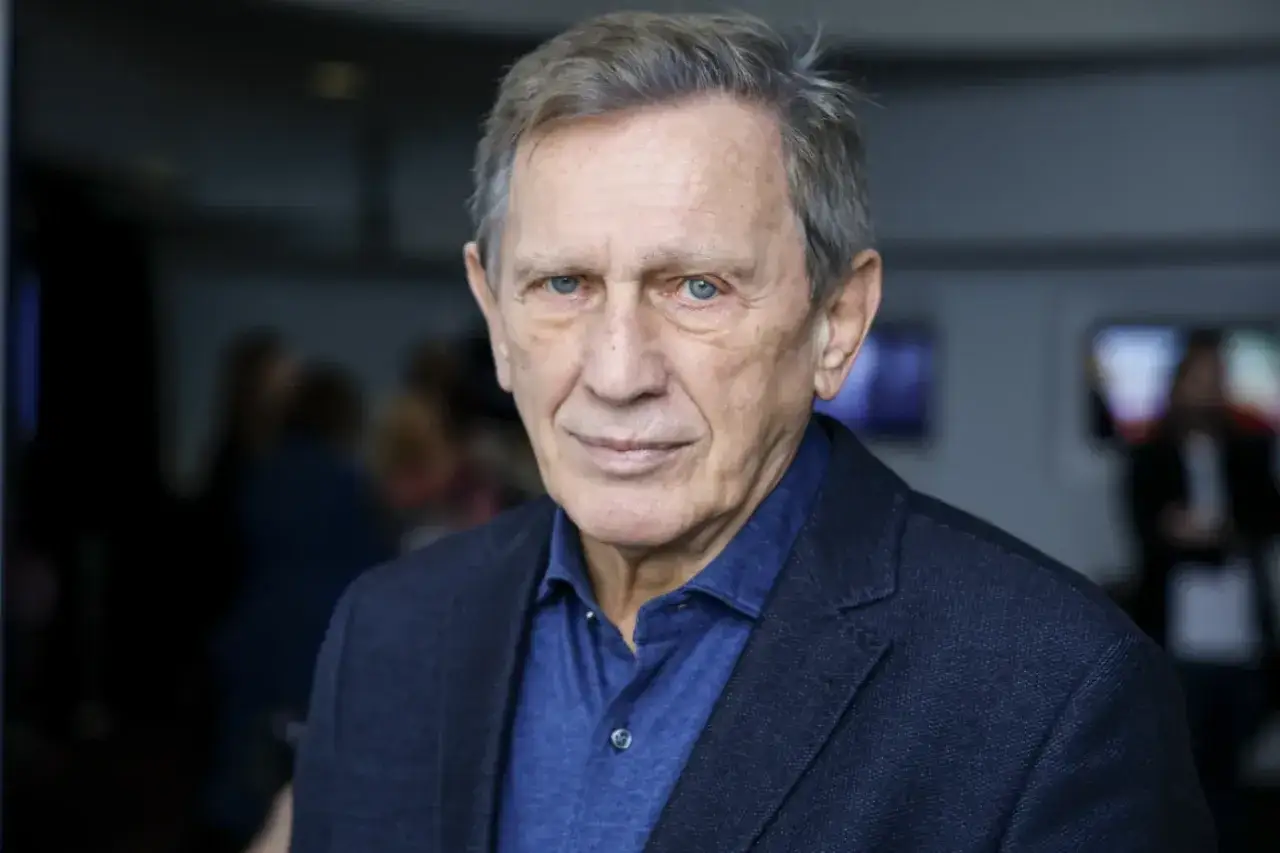 Portret Jana Englerta, aktora znanego z wielu filmów, w granatowej marynarce i koszuli.