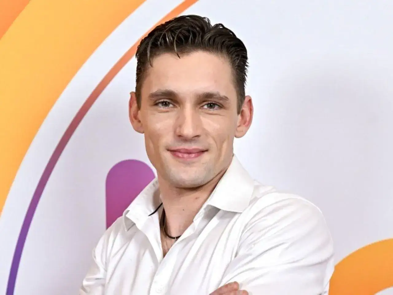 Filip Gurłacz w białej koszuli, uśmiechnięty, z pewnością zgadłby melodię w programie