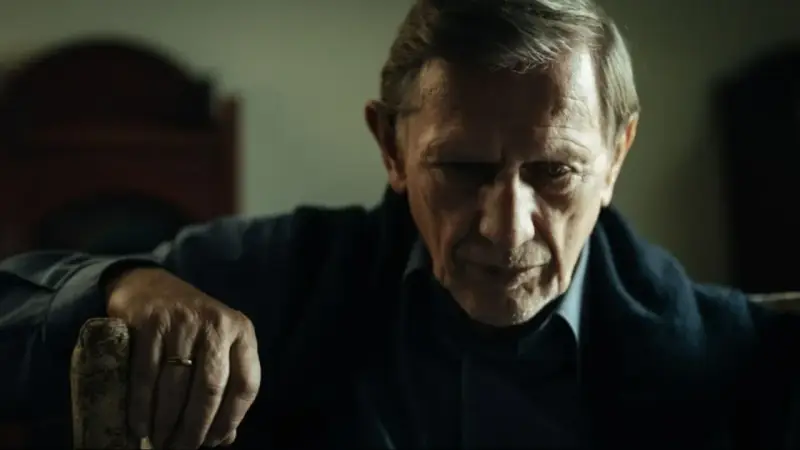Jan Englert w filmach, zamyślony, z dłonią opartą o laskę.