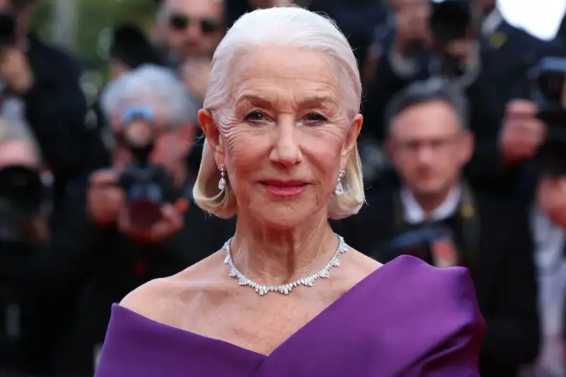 Helen Mirren w fioletowej sukni, olśniewająca na czerwonym dywanie. Jej bogata kariera obejmuje niezliczone filmy, seriale i programy.